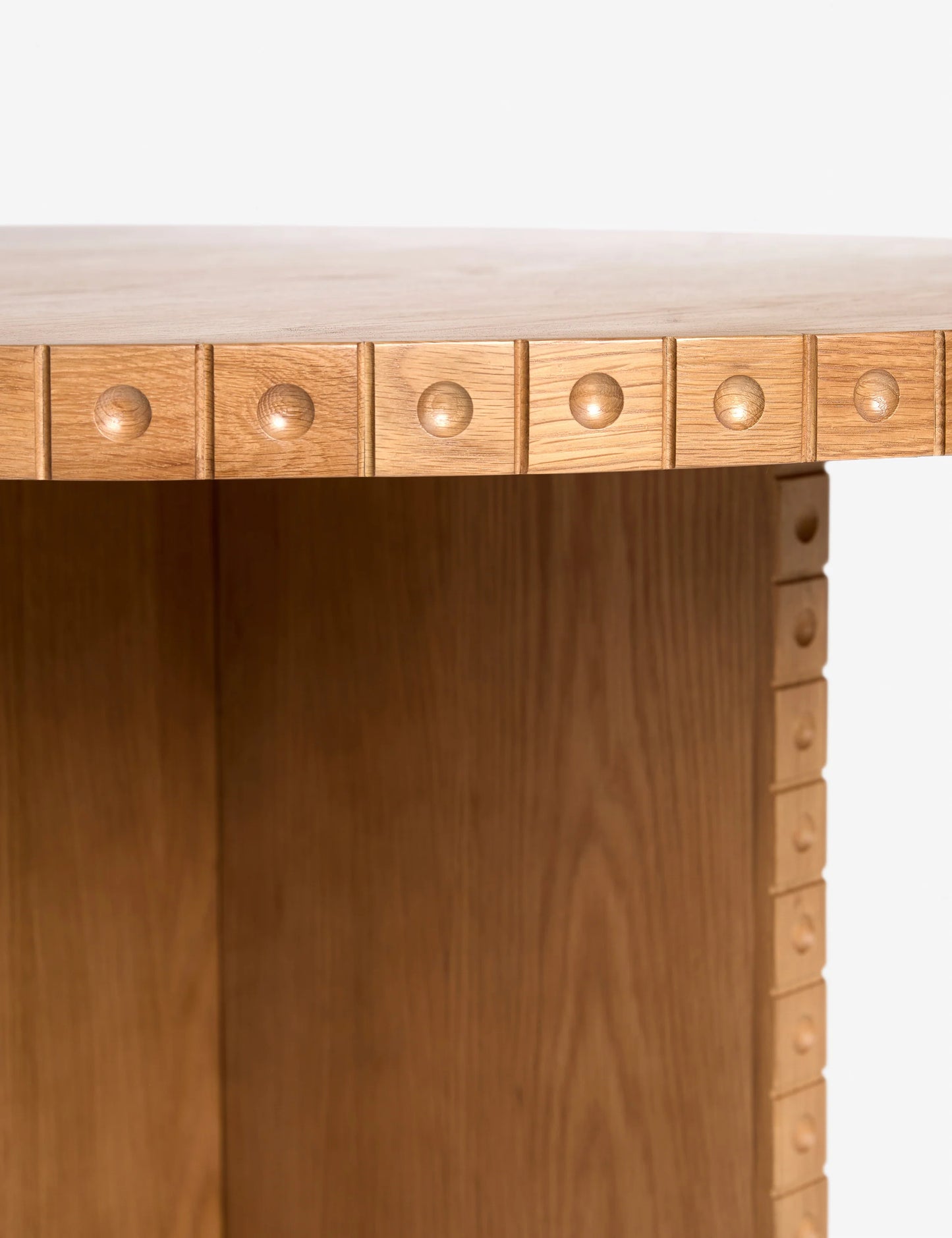 Close-up view of the sculptural dot trim detailing on the نور Nour Round Dining Table, highlighting artisanal craftsmanship