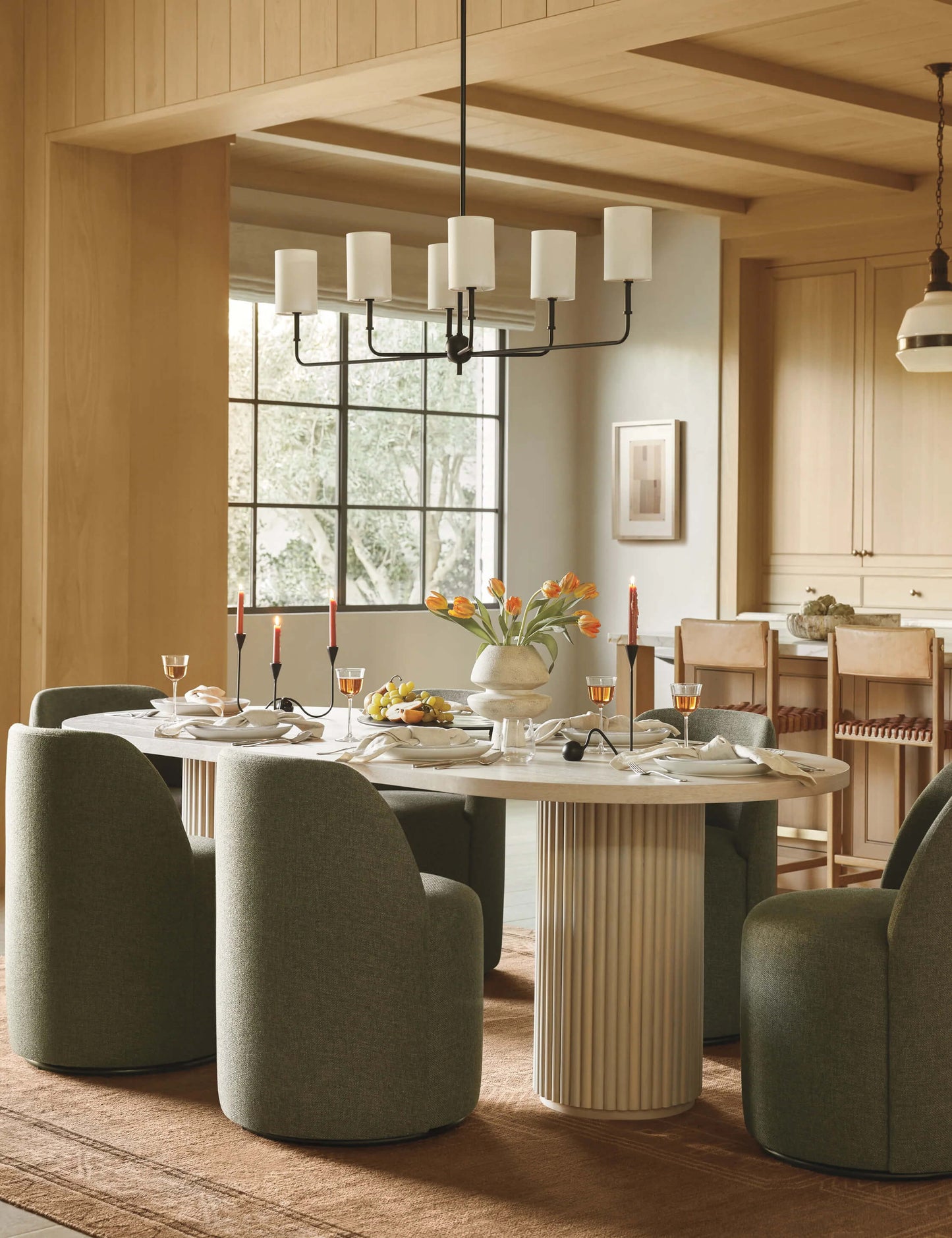 Meis Oval Dining Table styled in a luxurious dining room, featuring soft green upholstered chairs and elegant tableware.