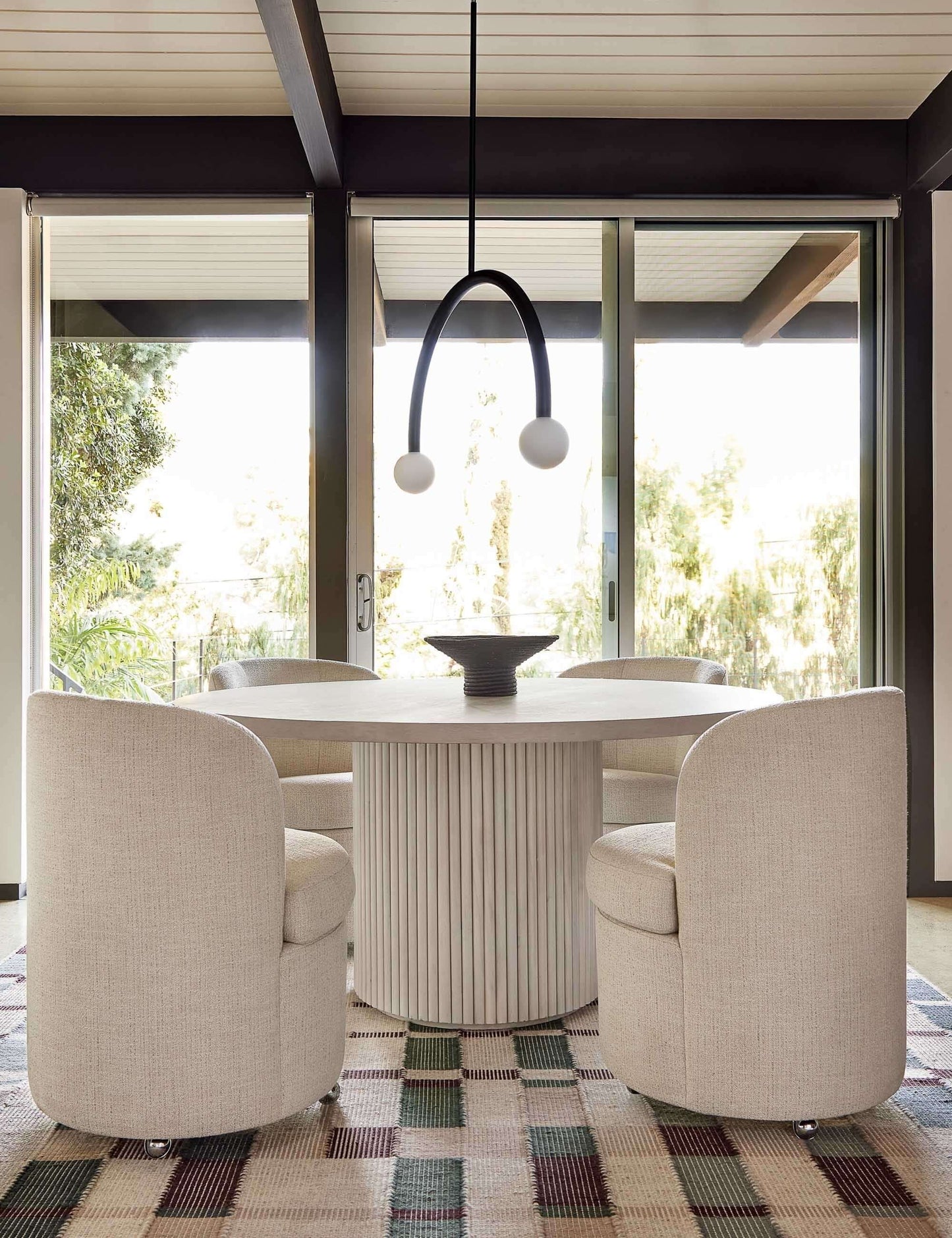Minimalist dining space featuring the Meis round table with a sculptural base.
